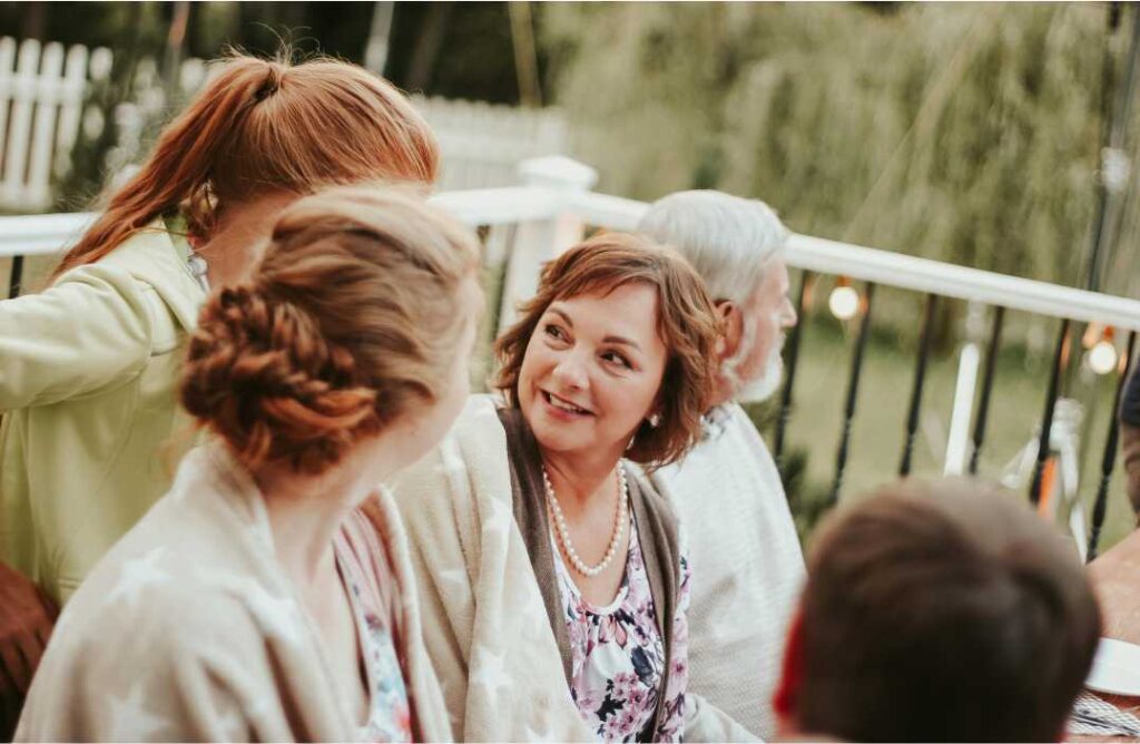 5 načina kako “ušutkati” neugodna pitanja na obiteljskim okupljanjima Nasmijana rodbina na obiteljskom okupljanju na terasi, prikazano kao ilustracija za temu neugodna pitanja na obiteljskim okupljanjima.