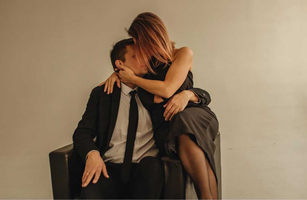 Par u elegantnoj odjeći u bliskom zagrljaju koji simbolizira pojam odrasla ljubav i stabilno partnerstvo.