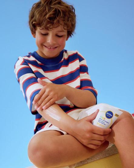 Dječak se maže s Nivea sun kids kremom.