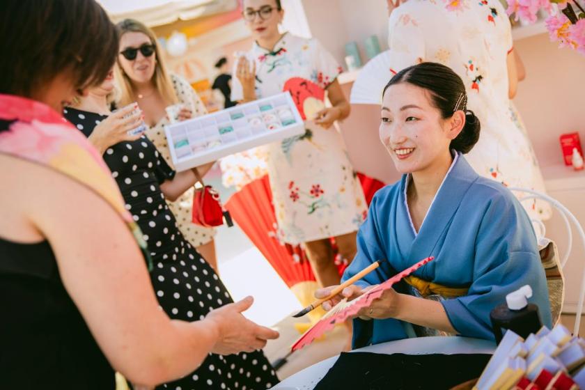 Oslikavanje lepeza imenom na štandu japanske kozmetike Yoskine, dok traje šesti dm beauty break.