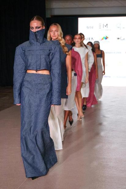 Model na čelu defilea na pariškoj pisti nosi skulpturalnu tamnosivu jaknu s visokim ovratnikom i dugu suknju, dok ostali modeli prate u kreacijama brenda SABOA.