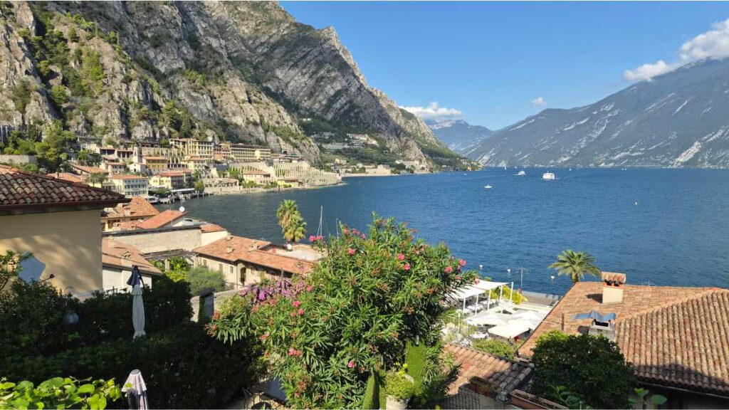 Panoramski pogled s povišenog dijela grada Limone sul Garda na tirkizno jezero, krovove kuća i strme alpske litice.