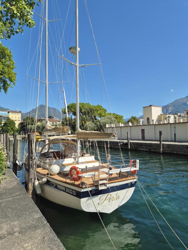 Drvena jedrilica usidrena u mirnom kanalu luke u gradu Riva del Garda na jezeru Garda.